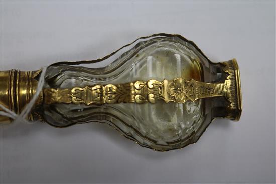 A late 18th century French yellow metal mounted glass scent bottle, with pierced removable finial.